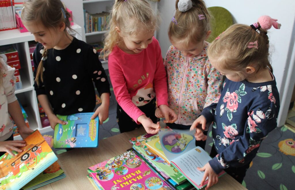 Grupa dziewczynek przegląda książki 