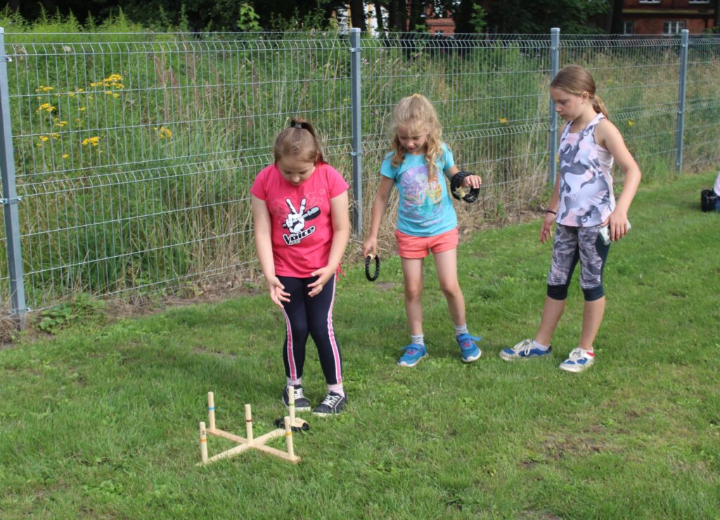 Zdjęcie przedstawia dziewczynki które grają w grę rzut do celu.