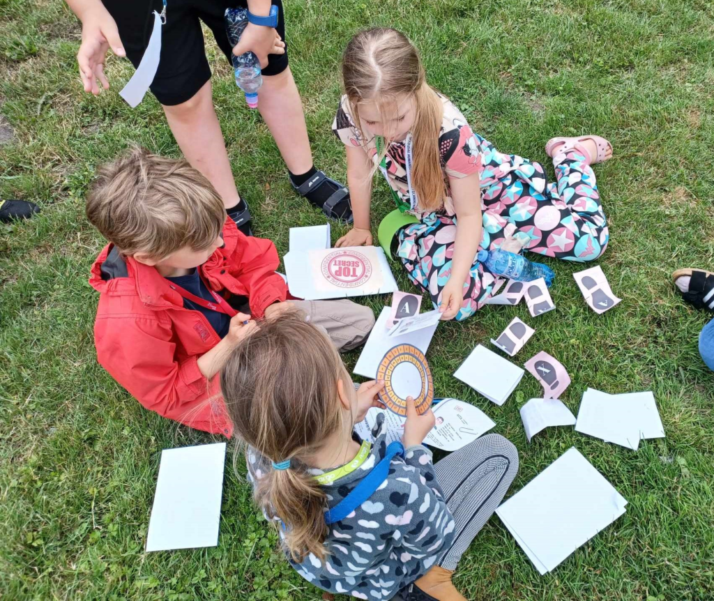 Zdjęcie przedstawia dzieci rozwiązujące zagadki.
