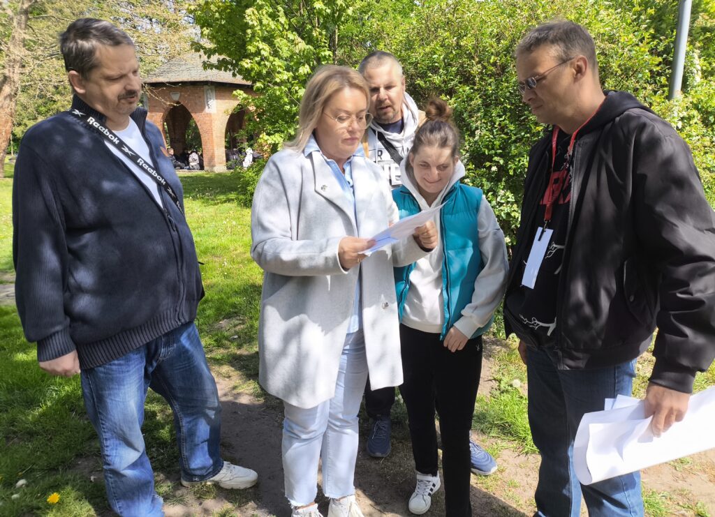 Na zdjęciu uczestnicy gry miejskiej, podczas rozwiązywania zadania.
