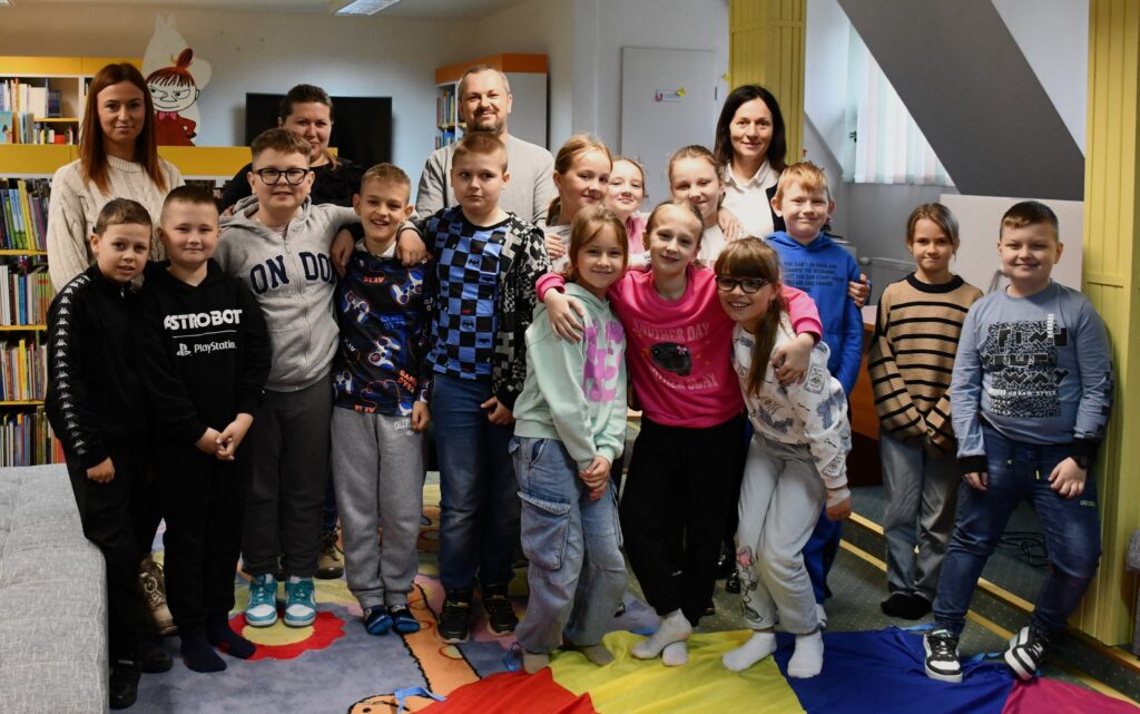 Grupowe zdjęcie uczestników spotkania autorskiego z Piotrem Krukiem.