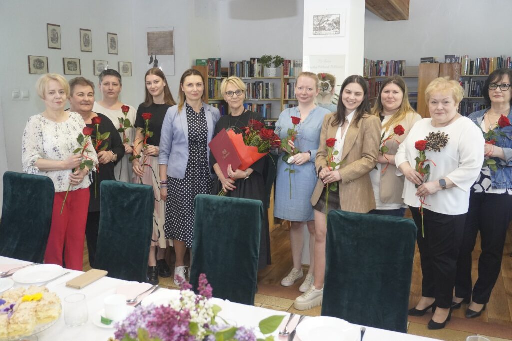 Grupowe zdjęcie bibliotekarzy z zaproszonymi gośćmi.