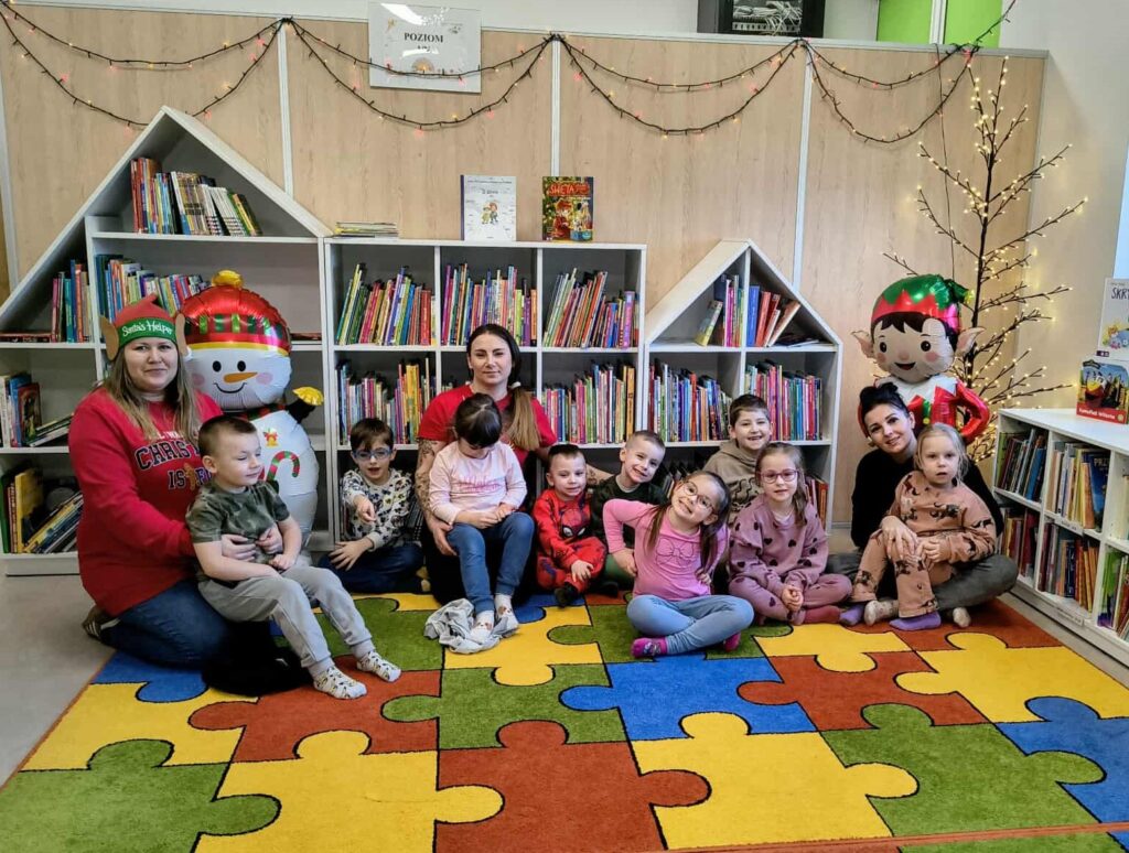 Na zdjęciu przedszkolaki z panią bibliotekarką i wychowawcami.