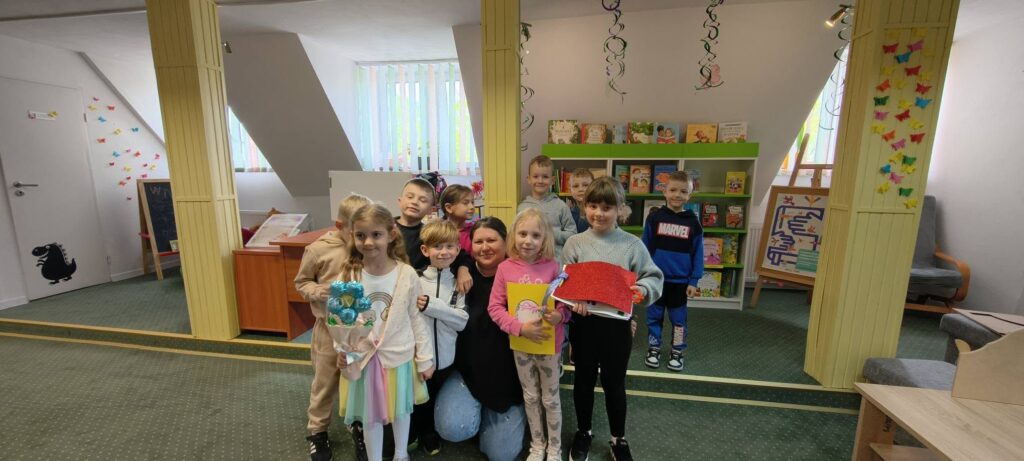 Na zdjęciu grupa przedszkolaków z panią bibliotekarką.