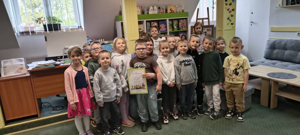 Na zdjęciu przedszkolaki z bibliotekarką.